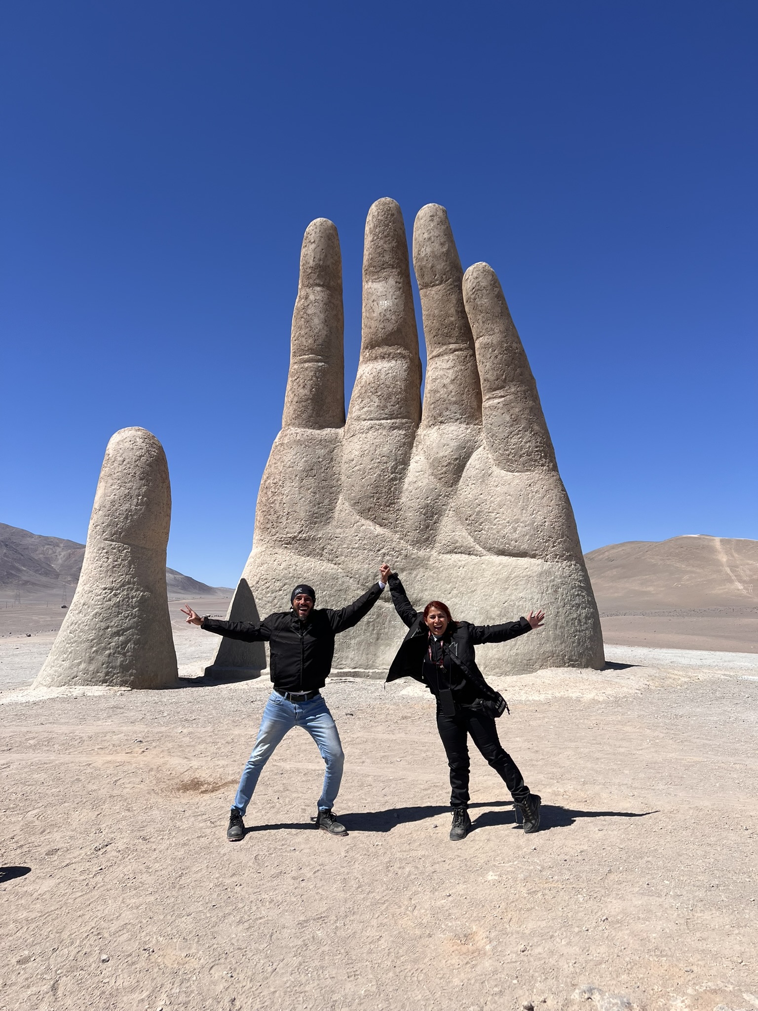 Chegada triunfal das motocicletas Harley-Davidson estacionadas em frente ao famoso monumento da Mano del Desierto no Chile
